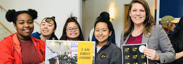 Students with staff, holding a sign that says "I am First @UMBC"