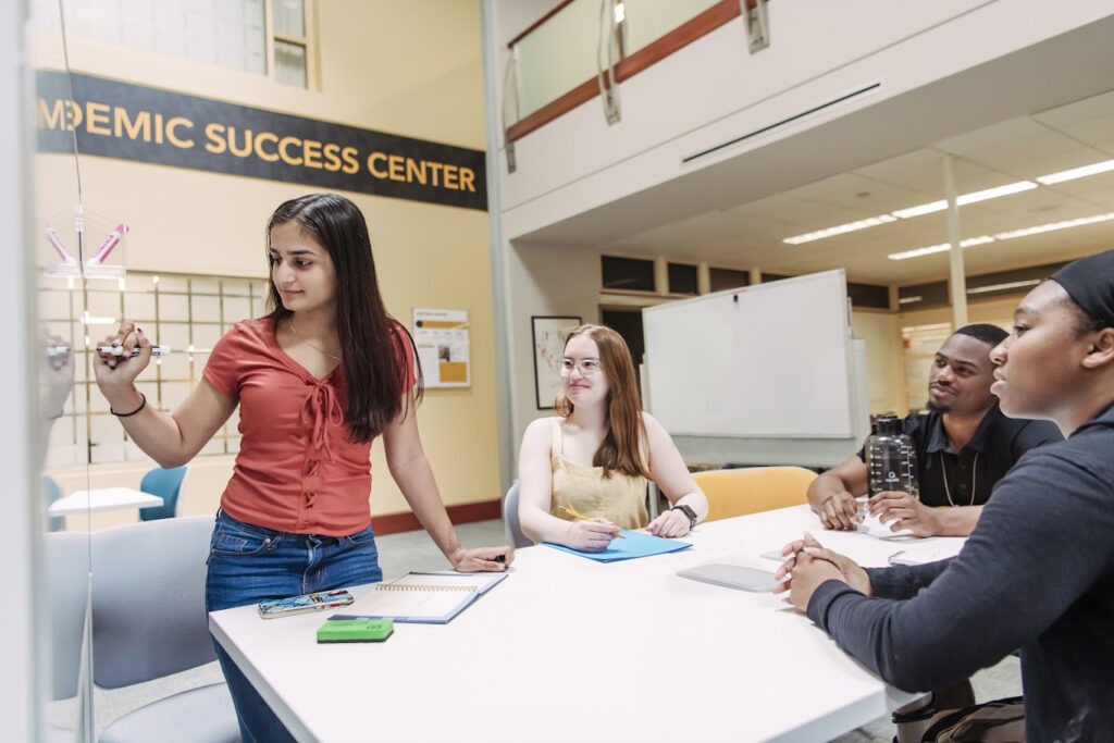 Students being tutored around desk in Library Academic Success Center