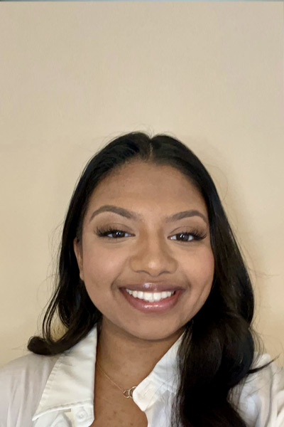 A three quarter portrait of a young woman smiling.