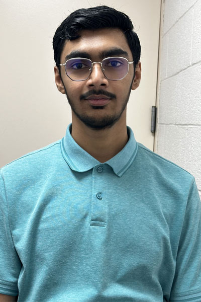 A young undergraduate standing in a hallway