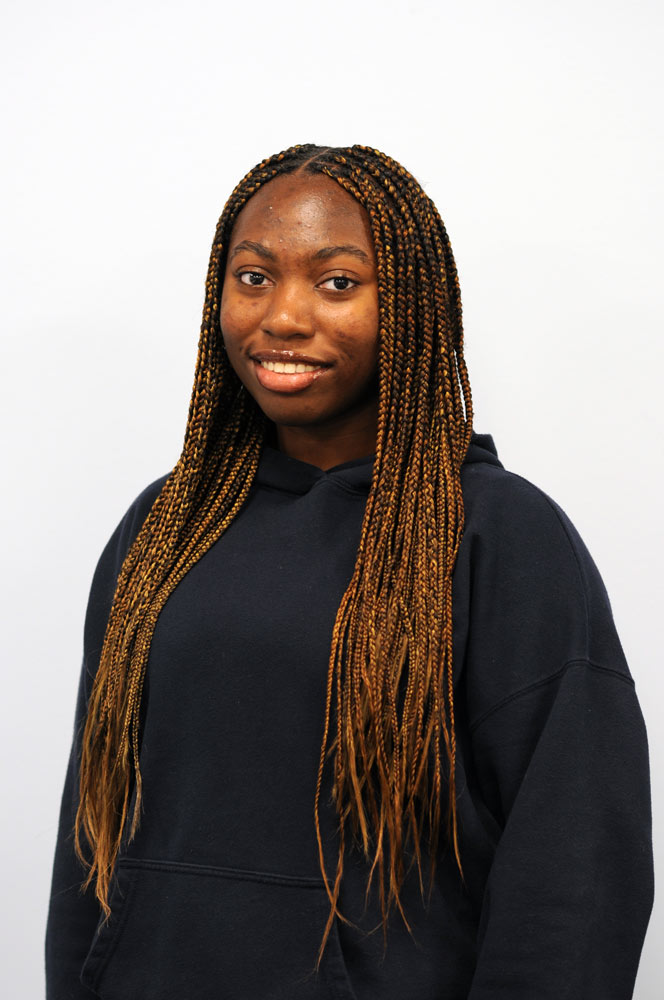 A three quarter portrait of a young woman smiling.