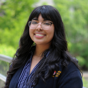 College staffer smiling outside in a courtyard
