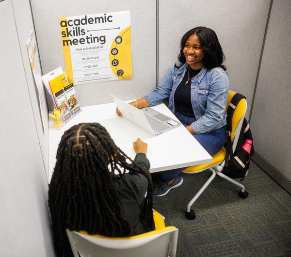 A advisor meeting with a student discussing a topic