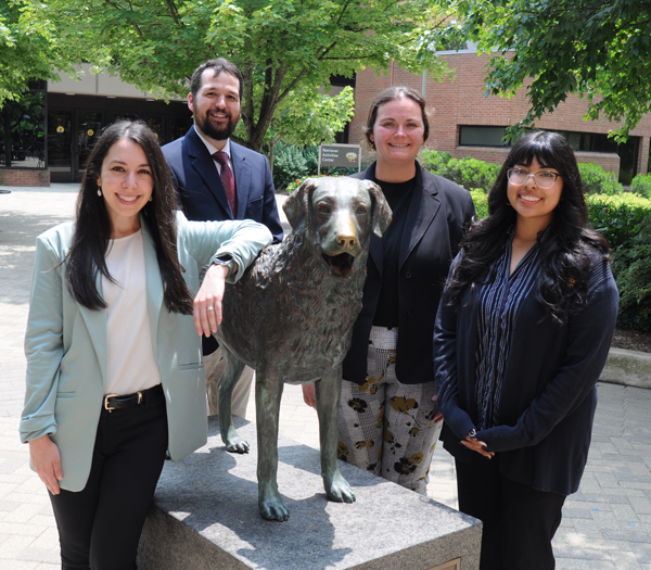 Advocates standing around a statue of a golden retreiver